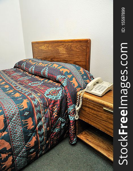 Single bed with phone on side table. For tourism, travel and backpacking concepts