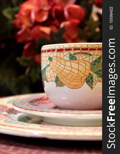 A set of decorative tea cup and plates with background of flowers, shallow dof