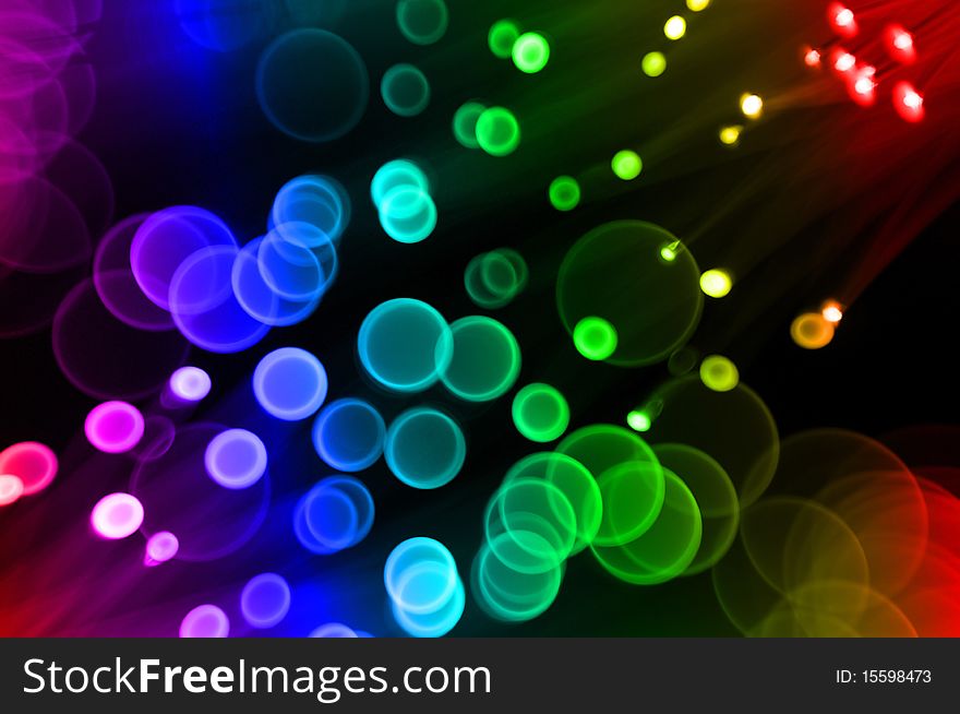 A blurry defocused background with round glowing circles as the bokeh shape with rainbow color. A blurry defocused background with round glowing circles as the bokeh shape with rainbow color