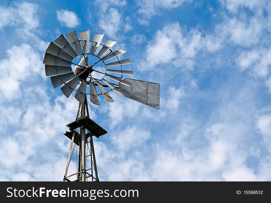 Old Metal Windmill Against Cloudy Sky