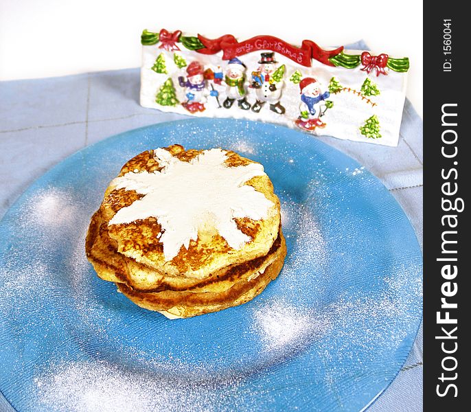 Homemade pancakes with powdered sugar and snowman decoration