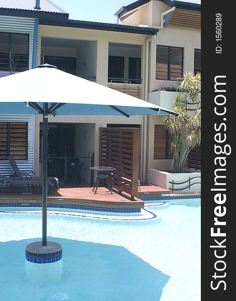 Balcony and umbrella next to outdoor hotel pool. Balcony and umbrella next to outdoor hotel pool
