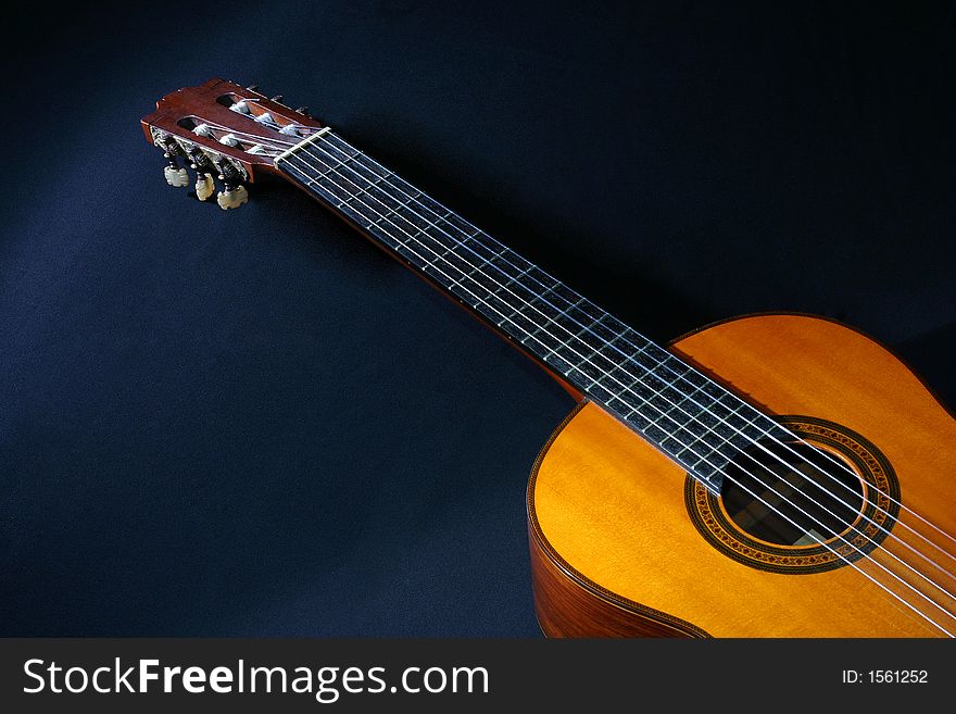 Acoustic guitar laying on black background