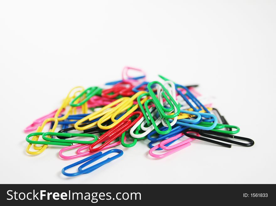 A pile of coloured paper clips on white background. A pile of coloured paper clips on white background.