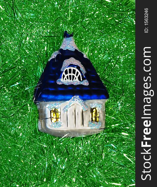 Christmas glass decoration coloured little house on green background