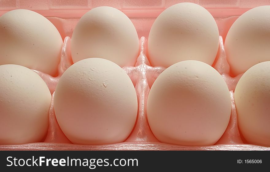 Closeup of White eggs in pink carton