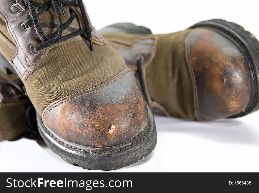 A pair of old boots that appear well worn and rugged.