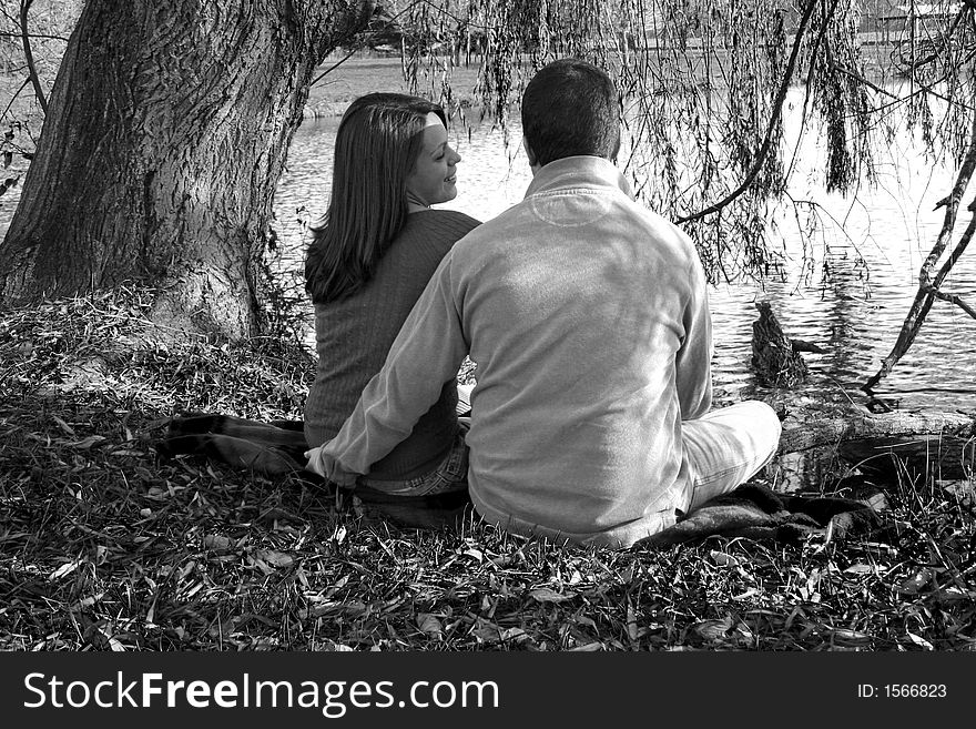 Young couple sitting under a tree. Young couple sitting under a tree