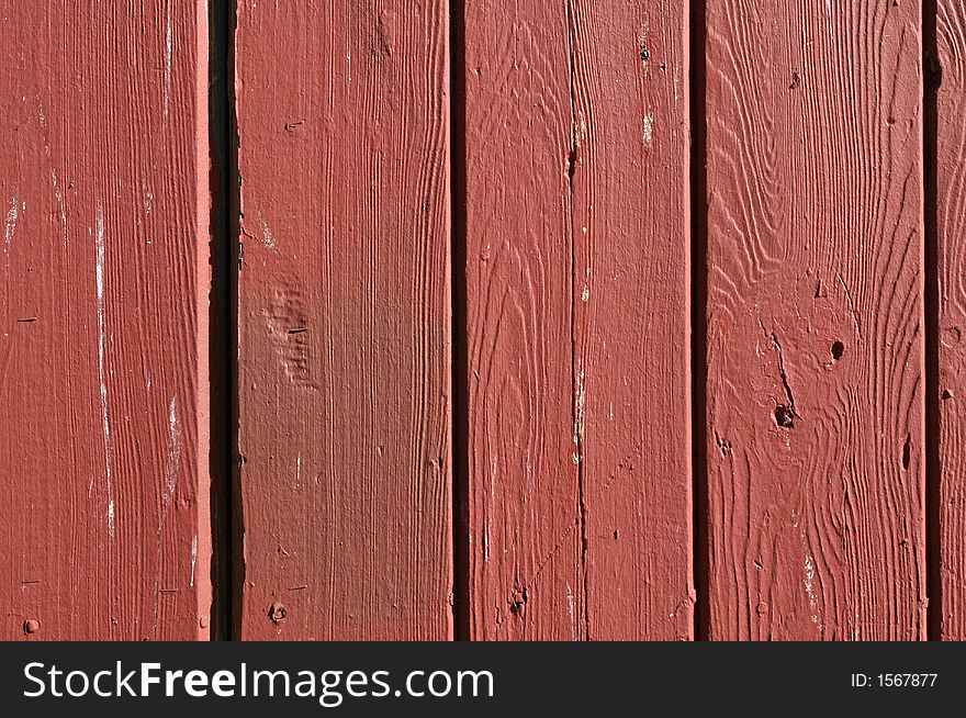 Detail on the boards and grain of a red fence. Detail on the boards and grain of a red fence