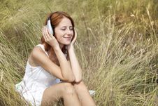 Beautiful Red-haired Girl At Grass With Headphones Royalty Free Stock Photography Beautiful Red-haired Girl At Grass With Headphones Royalty Free Stock Photography