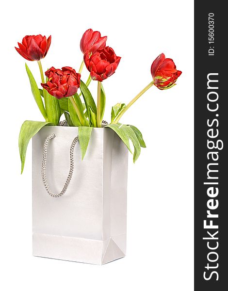 Five red tulips in silver paper bag isolated on white