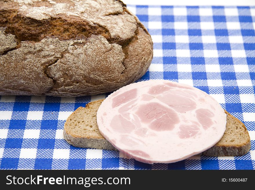Sausage and bread onto blue-white table cloth