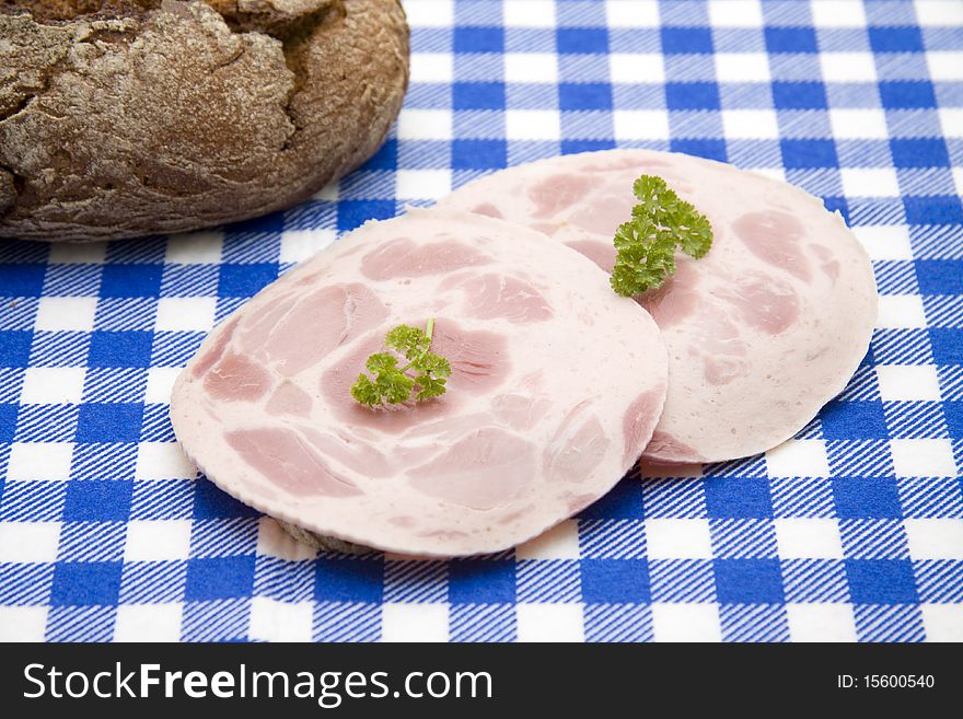 Sausage and bread onto blue-white table cloth