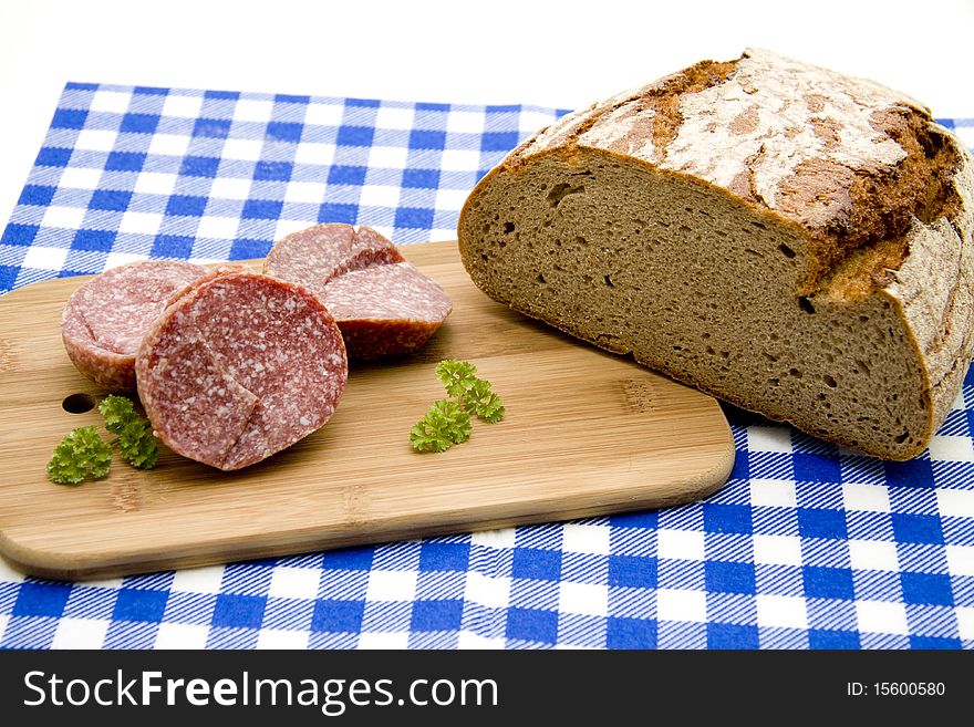 Sausage and bread on table cloth. Sausage and bread on table cloth