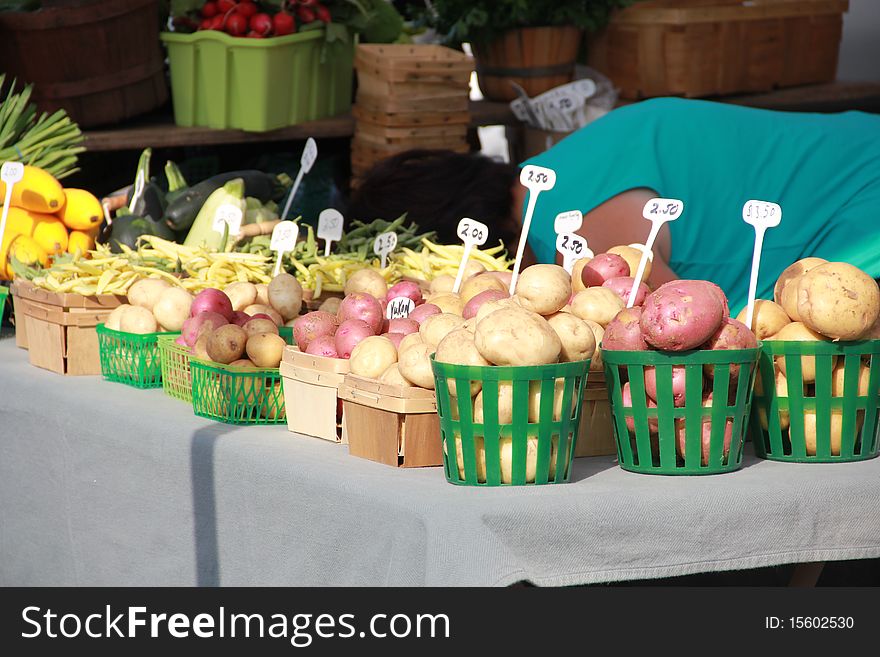 Potatoes and other vegetables in small baskets for sale at a farmers market. Potatoes and other vegetables in small baskets for sale at a farmers market