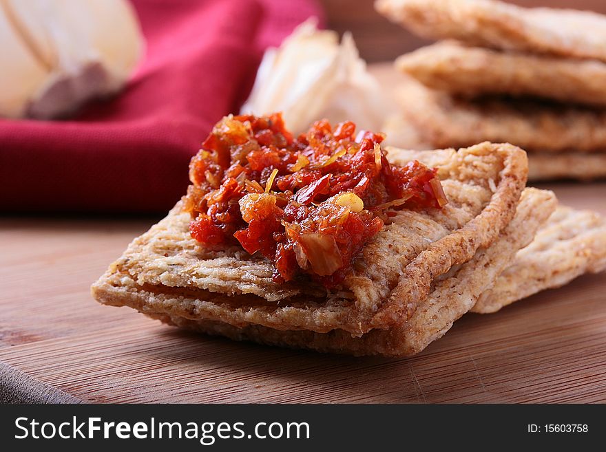 Wheat crackers on a kitchen board with a hot spice. Wheat crackers on a kitchen board with a hot spice.