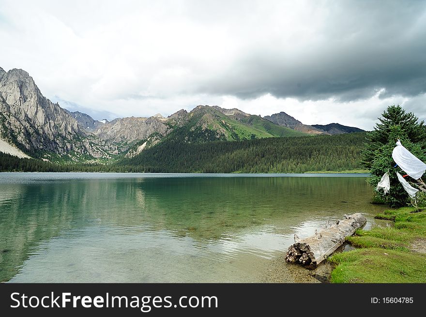 Highland lake, green grass, mountain and white clouds. Highland lake, green grass, mountain and white clouds