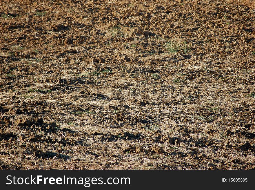 View of a freshly plowed farm field. With a texture of removed sand. View of a freshly plowed farm field. With a texture of removed sand.