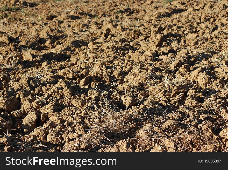 View of a freshly plowed farm field. With a texture of removed sand. View of a freshly plowed farm field. With a texture of removed sand.