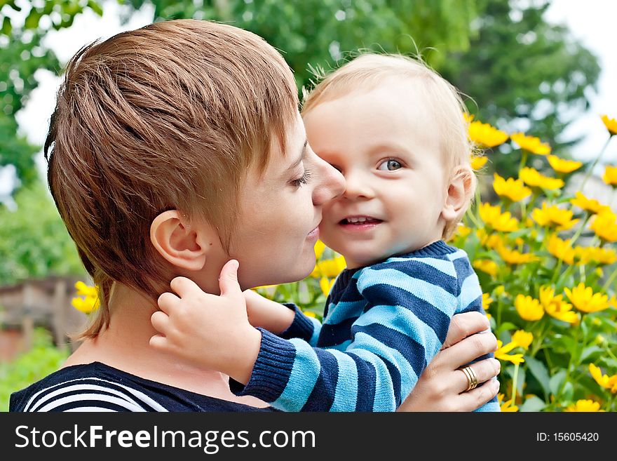 Mother embracing little son outdoors