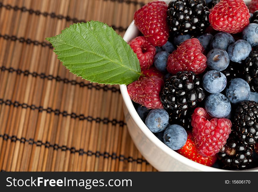 A collection of berries in a bowl on a table. A collection of berries in a bowl on a table