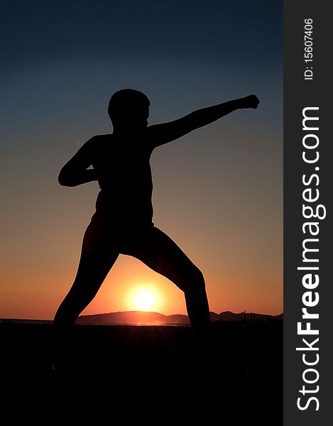 Boy doing exercise at sunset on beach. Boy doing exercise at sunset on beach