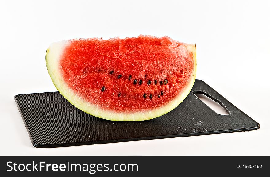 Piece of water-melon on black chopping board