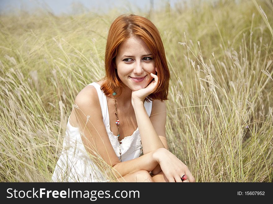 Beautiful red-haired girl at grass