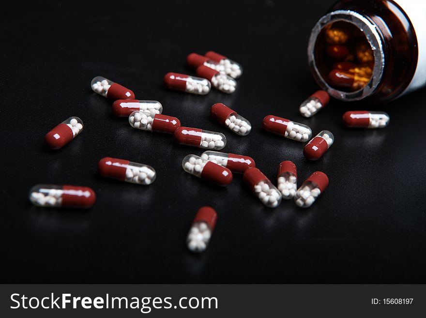 Vial with tablets. Black background. Vial with tablets. Black background