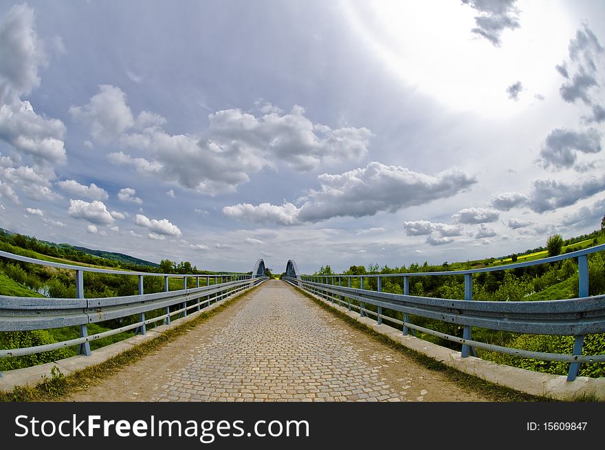 Steel bridge made with ultra wide lens - fisheye, dramatic sky above