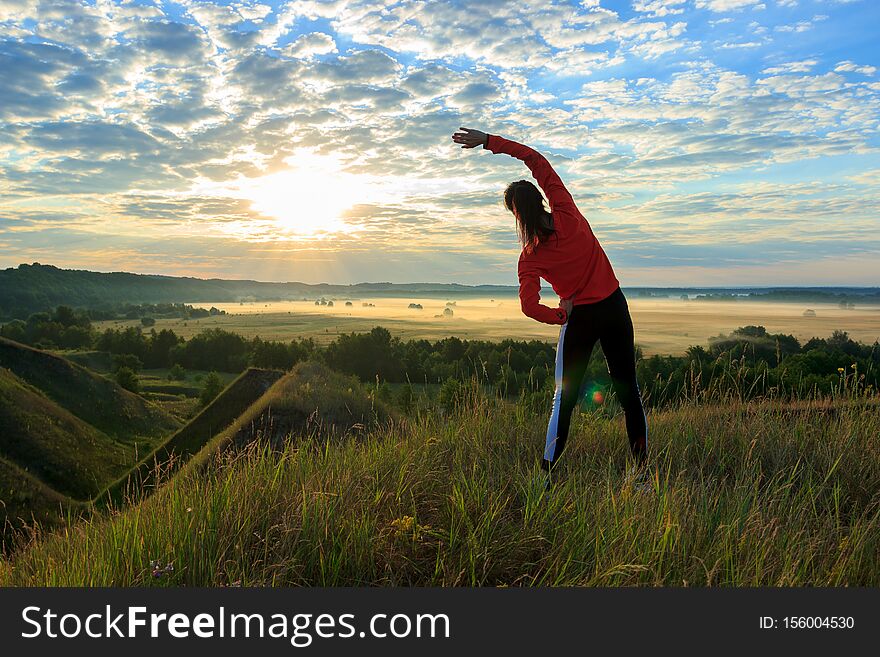 Girl in the nature doing yoga exercise for fitness, at sunrise