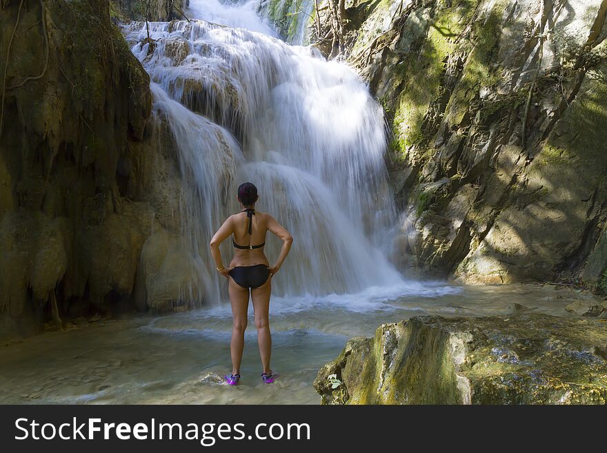 Woman with black bikini stand look waterfall