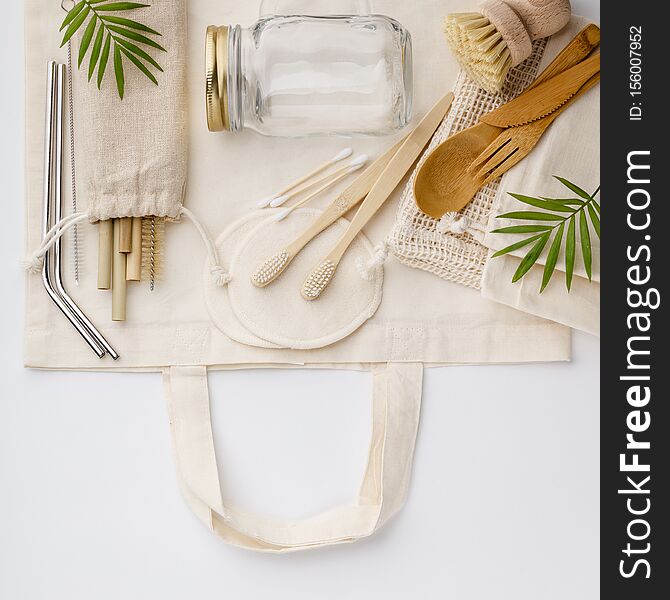 Natural color eco bags, reusable metal and bamboo straws, glass jars, wooden knifes and forks, zero waste cleaning and beauty products, flat lay. Natural color eco bags, reusable metal and bamboo straws, glass jars, wooden knifes and forks, zero waste cleaning and beauty products, flat lay