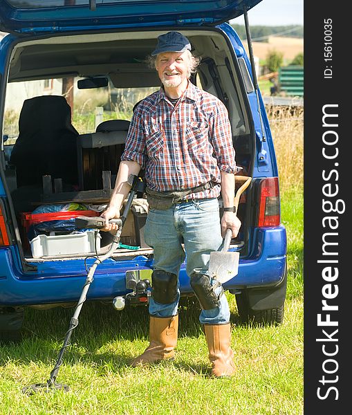An image of a senior with a metal detector getting ready to search a field for historic artifacts. An image of a senior with a metal detector getting ready to search a field for historic artifacts.
