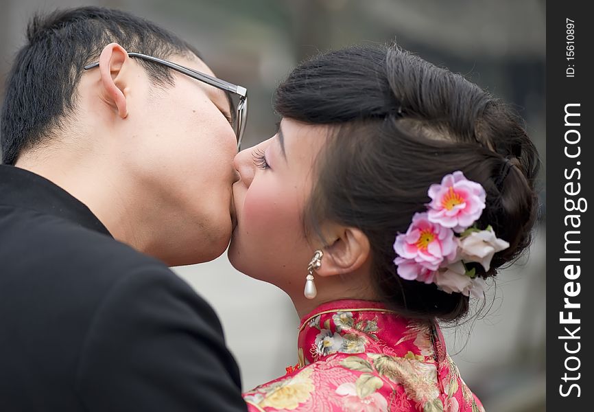 A young couple embracing and kissing on their wedding day. A young couple embracing and kissing on their wedding day