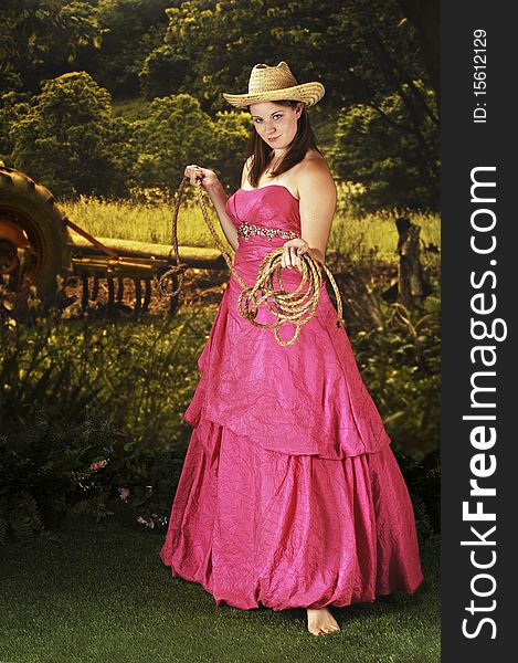 A beautiful teen in a cowboy hat and formal attire weilding a rope in a agricultural setting. A beautiful teen in a cowboy hat and formal attire weilding a rope in a agricultural setting.