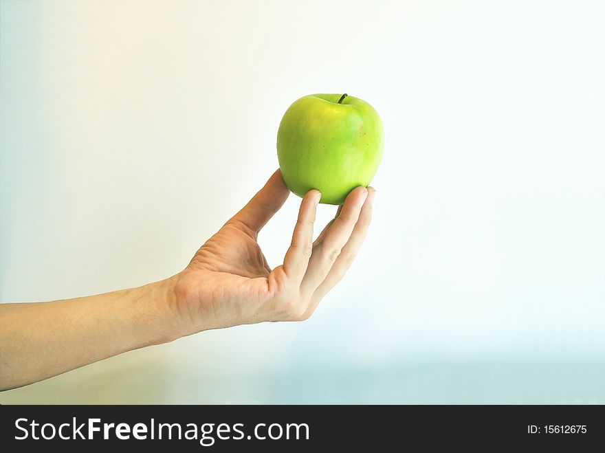 The Green Apple Is In The Fingers Against Colour B