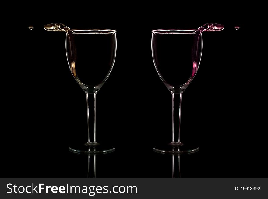 Wine pouring out of glasses isolated on black. Wine pouring out of glasses isolated on black