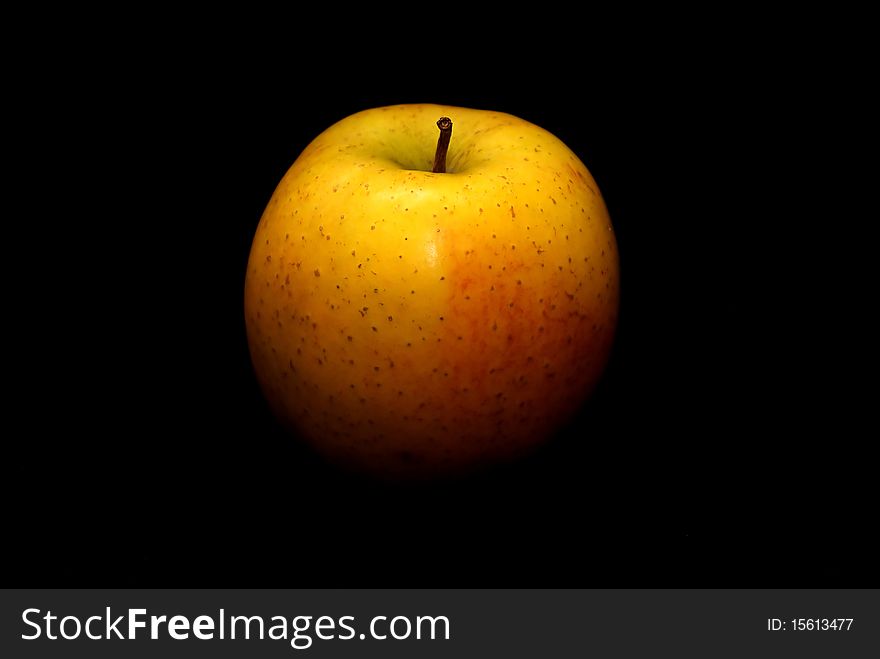 Yellow apple on a black background