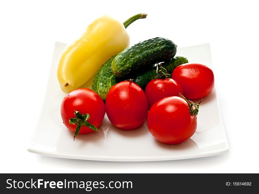 Tomato, cucumber and pepper in plate isolated on white background. Tomato, cucumber and pepper in plate isolated on white background
