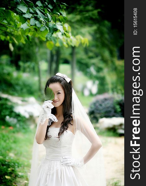 A portrait of a beautiful bride holding a green leaf. A portrait of a beautiful bride holding a green leaf