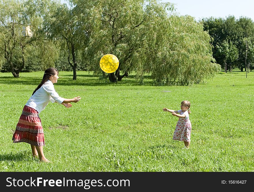 Mother and daughter playing ball on meadow. Mother and daughter playing ball on meadow