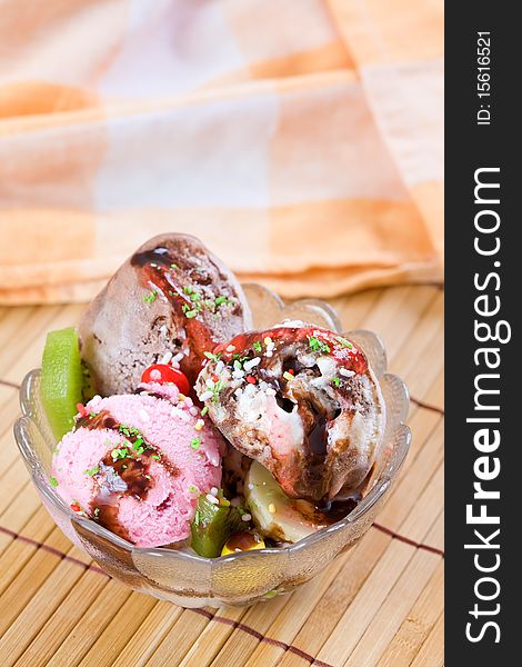 Glass cup with sweet icecream on wooden table top and a cloth on the background. Glass cup with sweet icecream on wooden table top and a cloth on the background