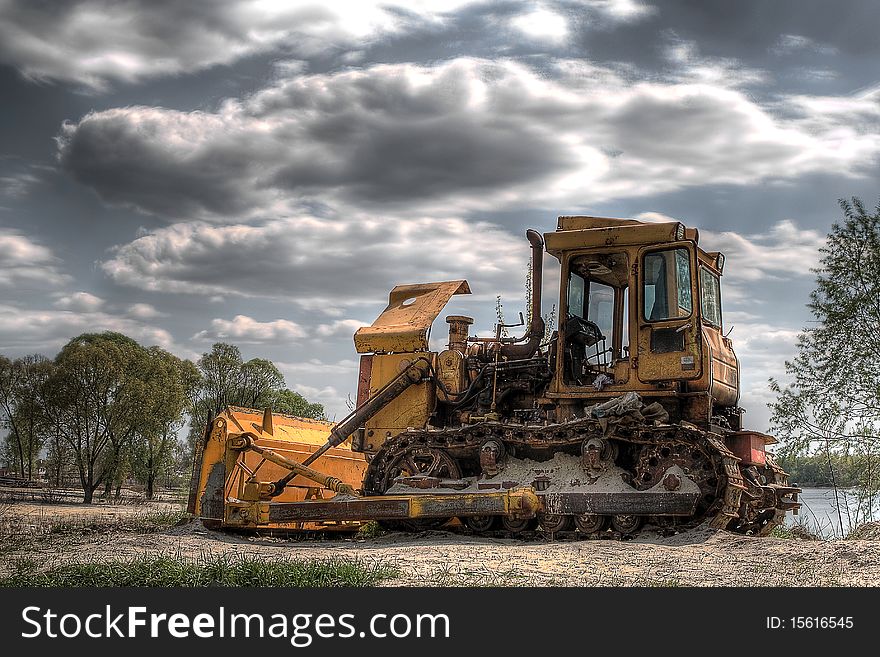 Old yellow bulldozer on nature background