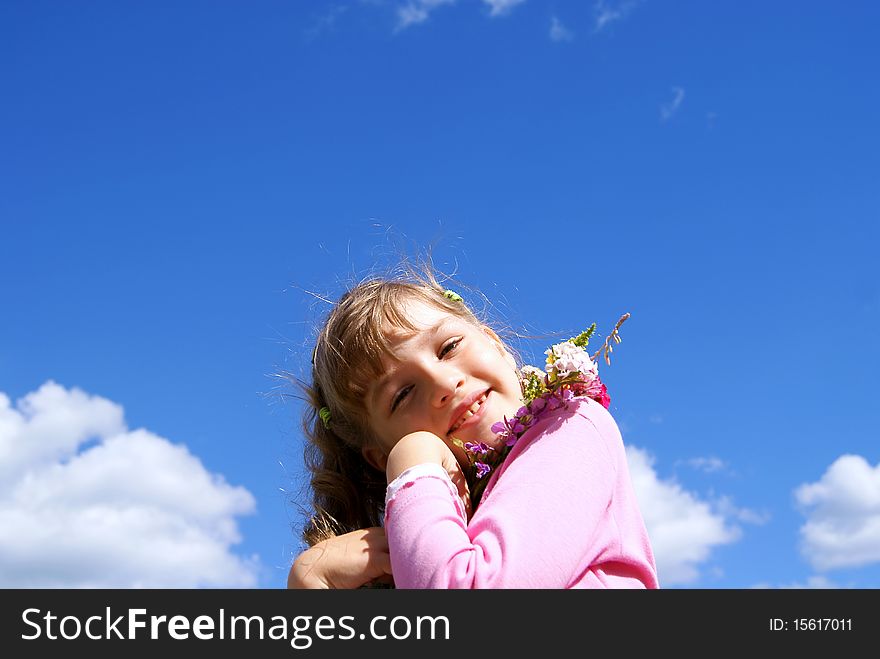 The beautiful smiling girl stands against the sky with a bouquet of wild flowers. The beautiful smiling girl stands against the sky with a bouquet of wild flowers