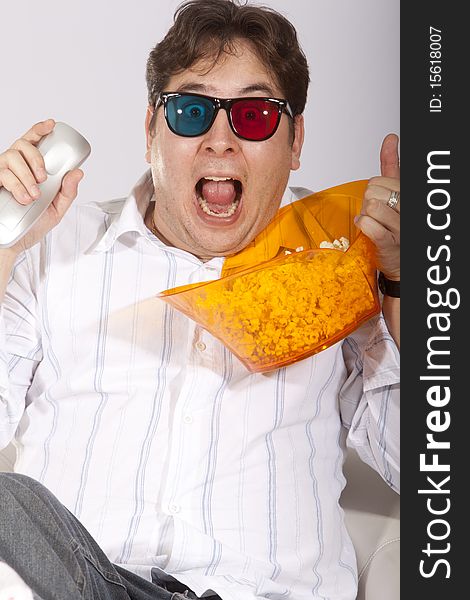 A young man watching a movie in 3D, with stylish 3D glasses and eating popcorn. A young man watching a movie in 3D, with stylish 3D glasses and eating popcorn.