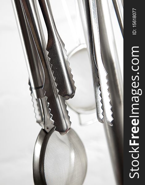 Kitchen utensils hangin in kitchen on a white background. Kitchen utensils hangin in kitchen on a white background.