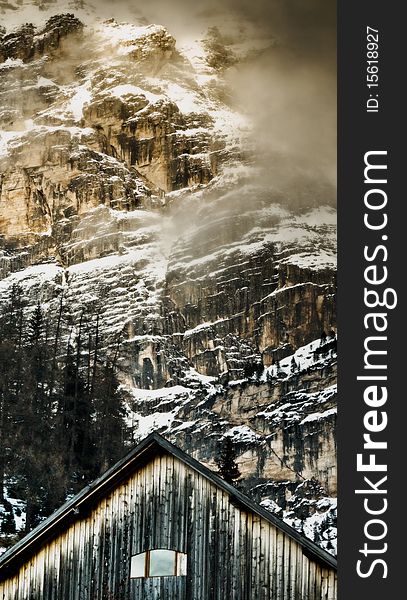 Old cottage in front of the snow-covered mountain, Dolomites, Val Badia, Armentarola, Italy. Old cottage in front of the snow-covered mountain, Dolomites, Val Badia, Armentarola, Italy