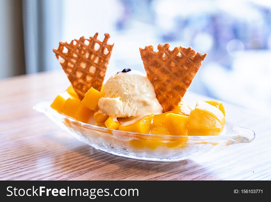 Fresh mango shaved ice with a scoop of ice cream and juice sauce in summer restaurant, lifestyle, popular food in Taiwan, close up