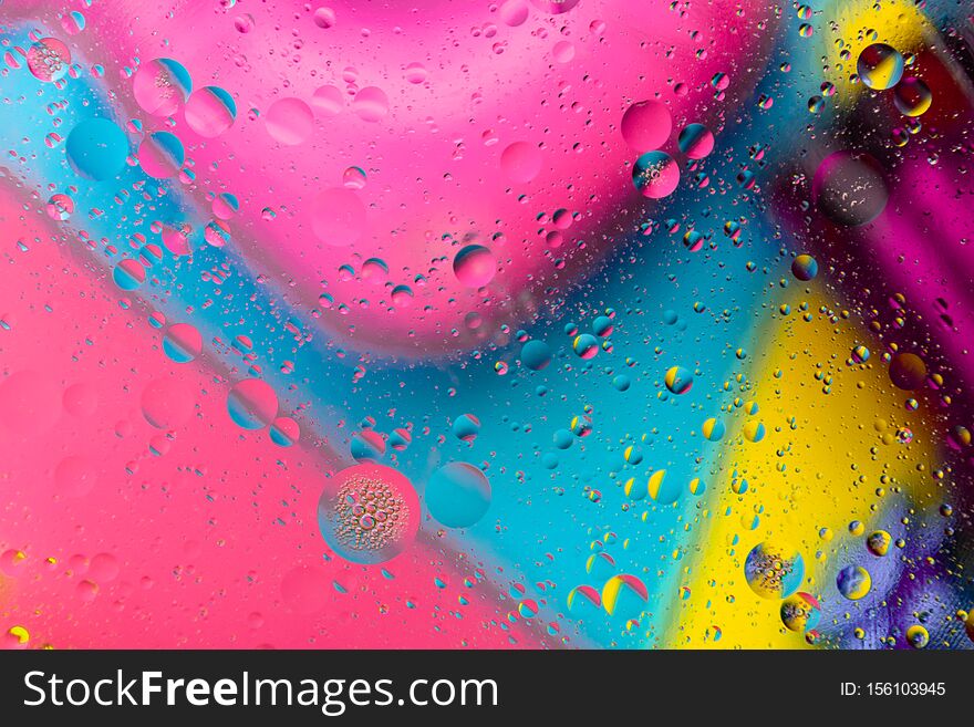 Micro molecular abstract pattern of colored oil bubbles on water.